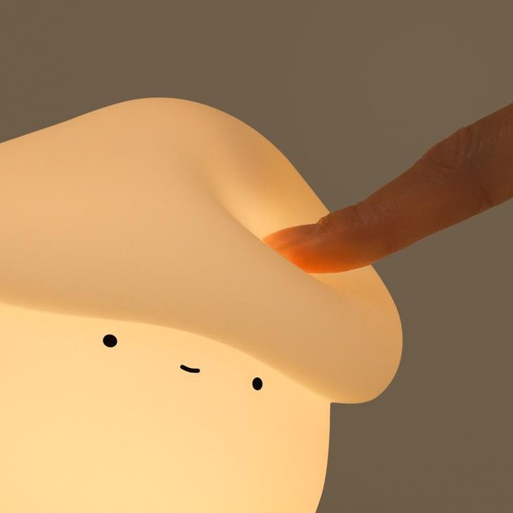 Person touching a cartoonish mushroom-shaped light with a neutral background