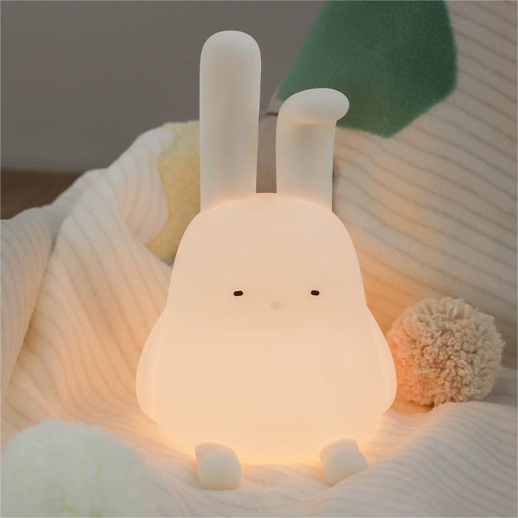 Adorable foldable ear bunny night light with soft silicone body, warm LED glow, tap control, phone stand & hanging function. Rechargeable & portable.