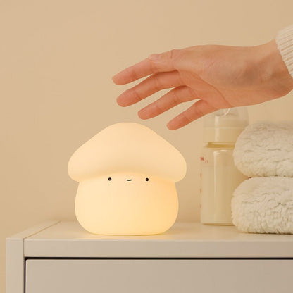 Mushroom-shaped night light being touched by a hand on a neutral background